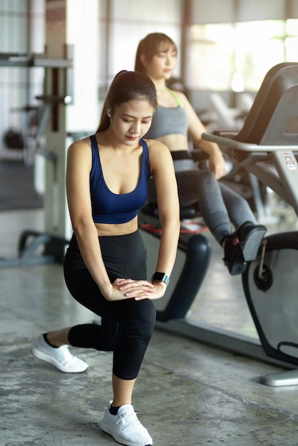 Une femme magnifique s'entraîne, s'étire les jambes et s'échauffe avant de faire de l'exercice en tant que centre de gym.