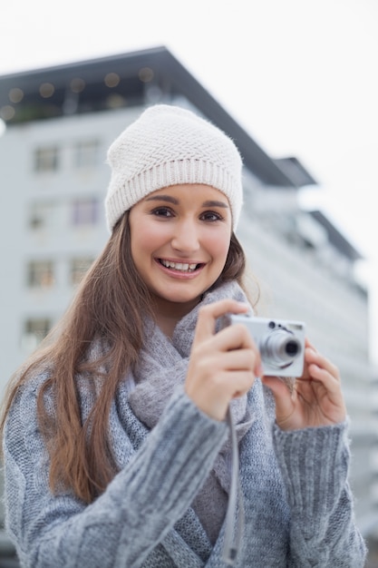 Femme magnifique souriante avec des vêtements d&#39;hiver sur la prise de photo