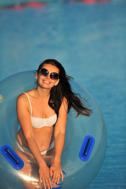 Une femme en maillot de bain blanc avec un cercle gonflable dans un parc aquatique