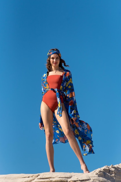 Une femme en maillot de bain rouge avec un imprimé de fleurs bleues et jaunes dessus.