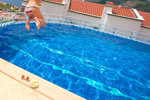 Femme en maillot de bain sautant dans la piscine