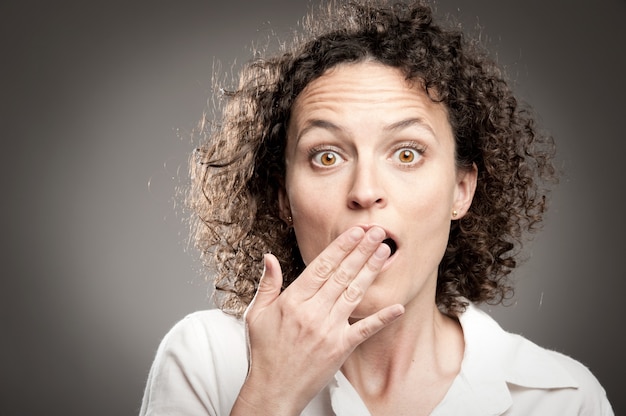 femme avec la main sur la bouche ouverte