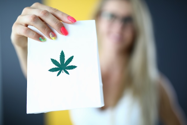 Femme main tenant un sac en papier avec de la marijuana