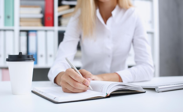 Femme main tenant un stylo argenté prêt à faire