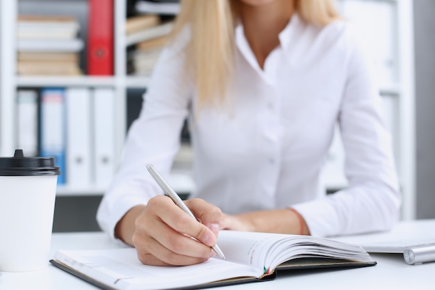 Femme main tenant un stylo argenté prêt à faire