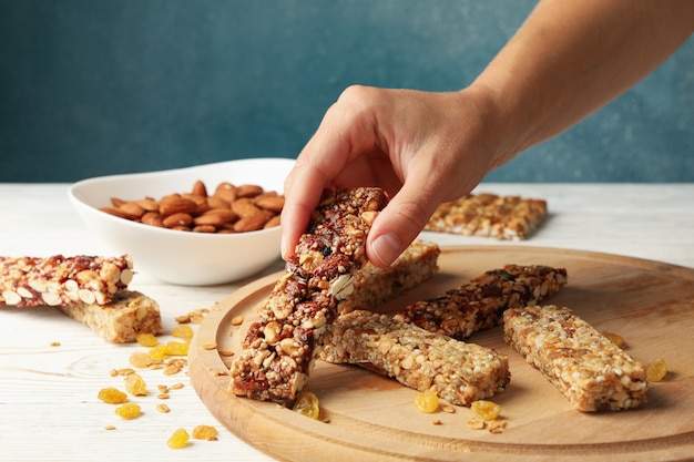 Femme main tenir la barre granola sur fond de bois avec des barres granola