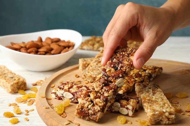 Femme main tenir barre granola sur fond de bois