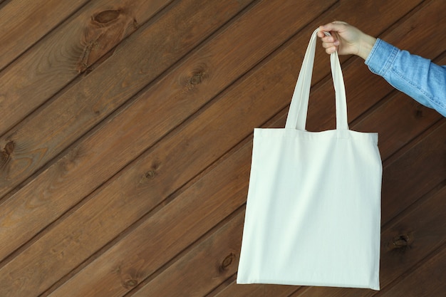 Femme main tenir le sac écologique sur une surface en bois