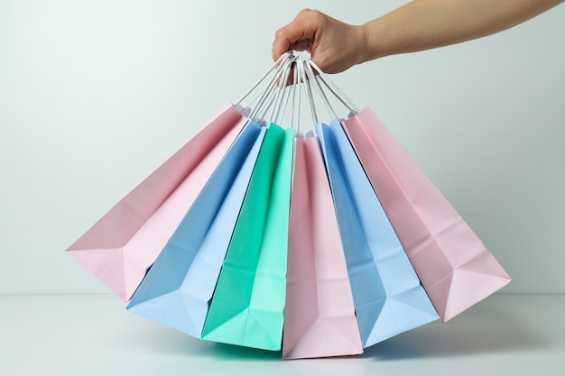 Femme main tenir des sacs en papier colorés sur fond blanc