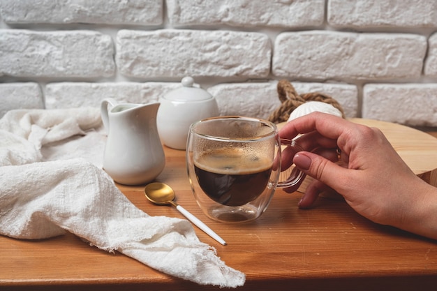 Femme main tient une tasse de verre avec café