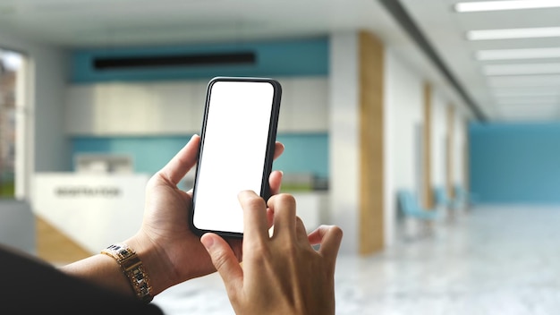 Une femme mains à l'aide d'un téléphone portable sur fond flou de la salle de réception de l'hôpital ou de la clinique