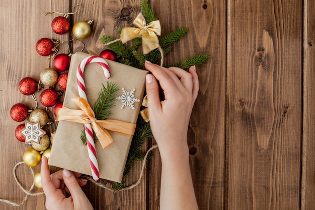 Femme, mains, emballage, cadeau noël, gros plan Cadeaux de Noël non préparés avec des éléments de décoration et des objets, vue de dessus. Concept d'emballage de bricolage de Noël ou du nouvel an.