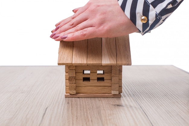 Femme mains sauver petite maison avec un toit