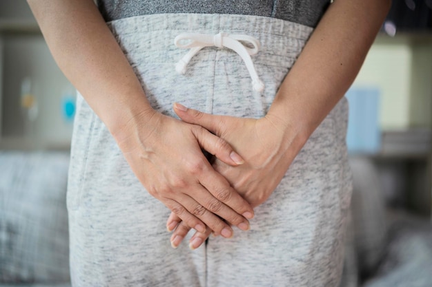 Femme avec les mains sur son entrejambe Concept d'hygiène de la santé