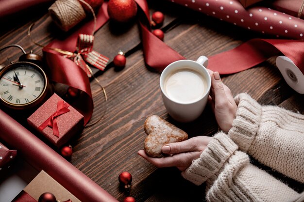 Femme mains tenant une tasse de café sur une table en bois dans le temps d'emballage