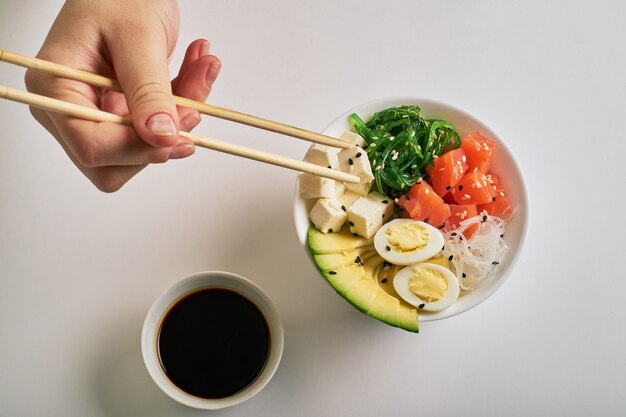 Femme, mains, tenue, baguettes, poke, bol, à, saumon, avocat