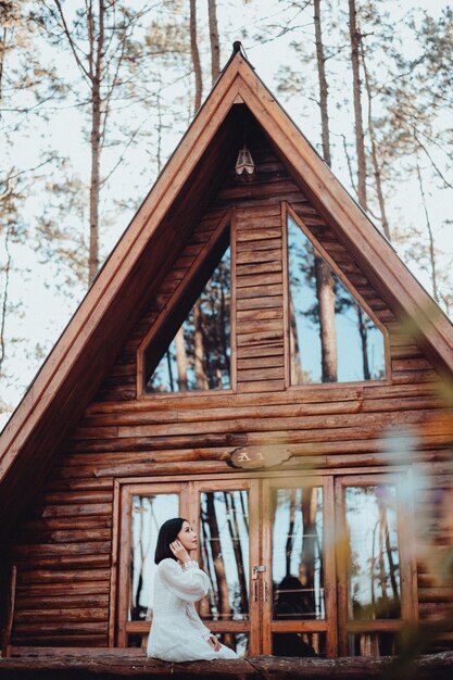 Photo une femme et une maison brune dans une forêt de pins