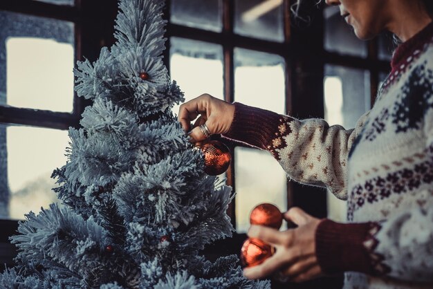 Femme à la maison décorant l'arbre de Noël