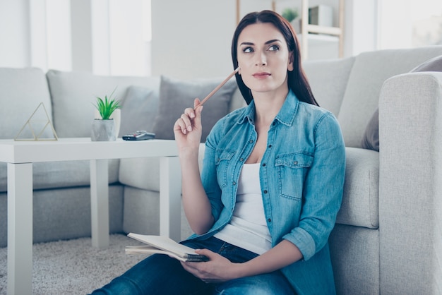 Femme à la maison écrit sur le bloc-notes