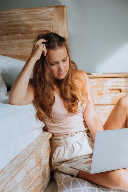 Femme à la maison avec ordinateur portable