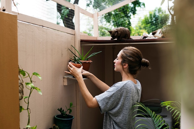 Femme à la maison avec des plantes et des chats