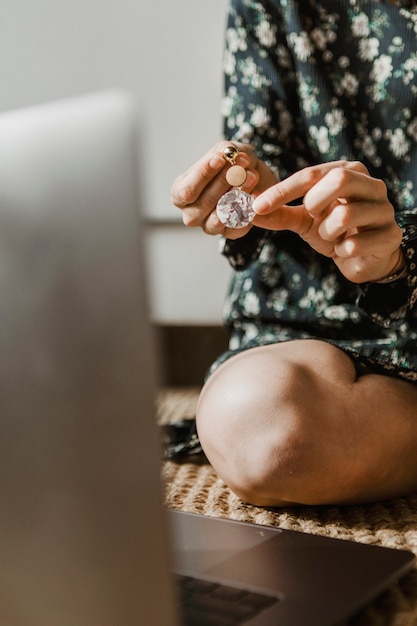 Femme à la maison tenant une boucles d'oreilles