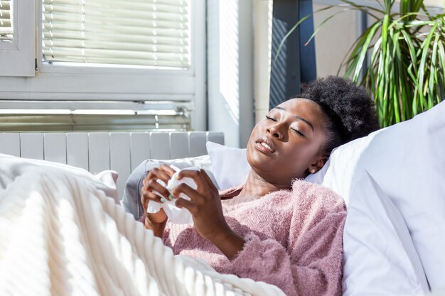 Femme avec mal de tête assis sous la couverture