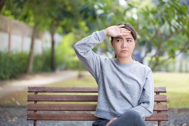 Femme a mal à la tête au parc