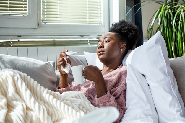 Femme malade buvant une tasse de thé chaud