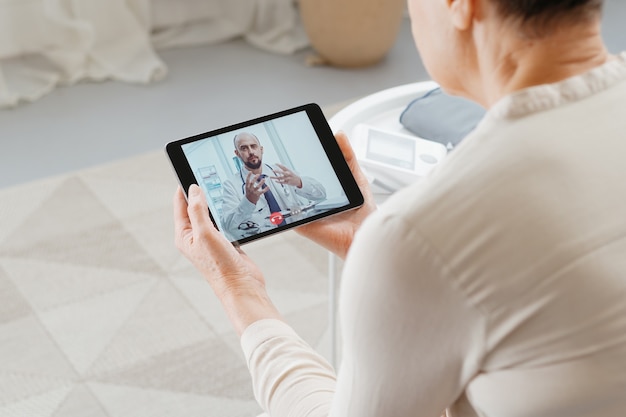 Femme malade consultant un médecin par liaison vidéo.