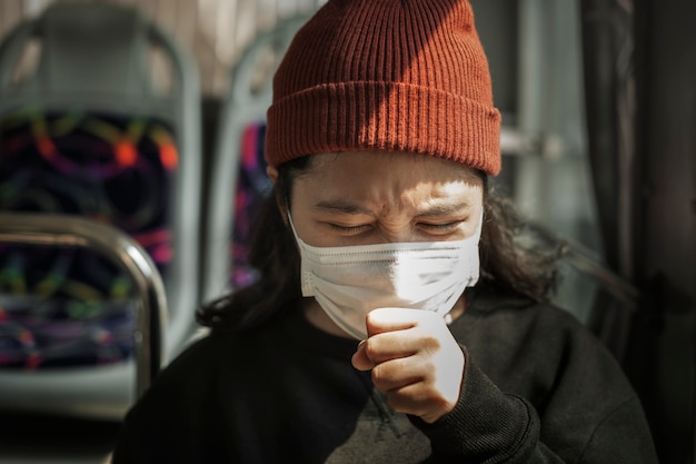 Femme malade dans un masque toussant en public pendant la pandémie de coronavirus