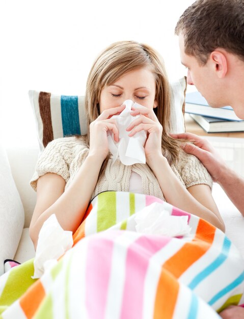 Femme malade avec du tissu allongé sur un canapé