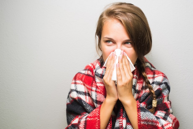 Femme malade en essuyant un nez