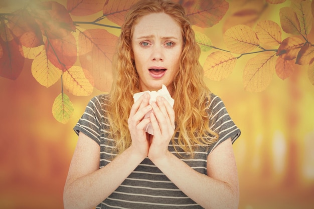 Photo femme malade éternuant dans un tissu contre la scène d'automne