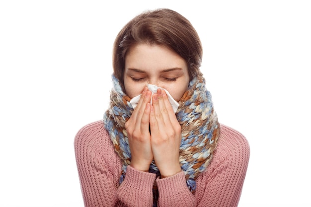 Femme malade éternue sur fond blanc