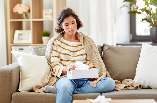 Photo femme malade prenant des mouchoirs de papier de la boîte à la maison