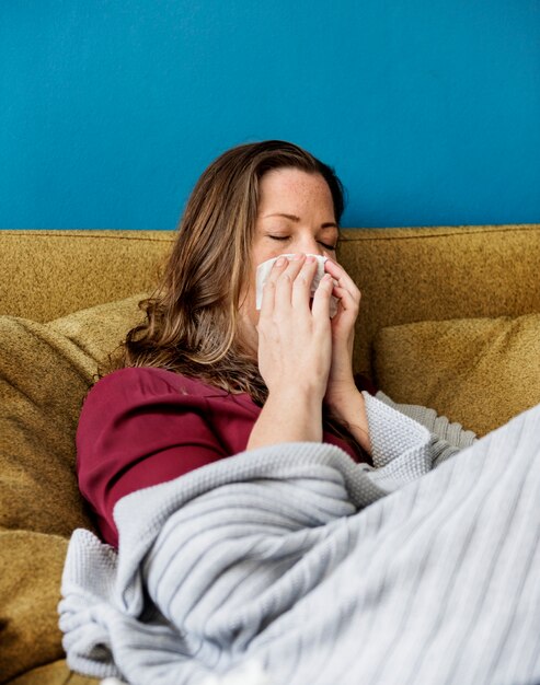 Femme malade sur le sofa