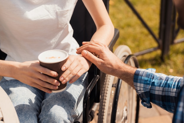 Femme malade tient un verre avec du café dans les mains.