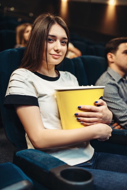 Une femme mange du pop-corn en regardant un film au cinéma