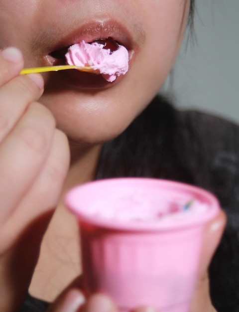 Une femme mange un gâteau délicieusement.