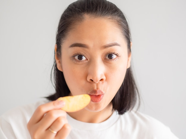 La femme mange un morceau de pomme.