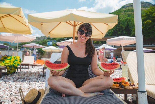 Femme mangeant des fruits aux vacances d'été de plage