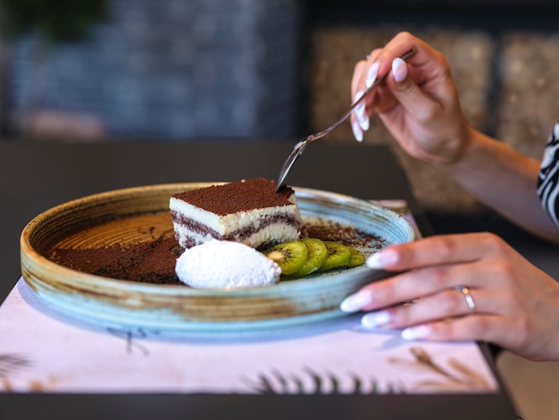 Une femme mangeant un gâteau au chocolat dans un café