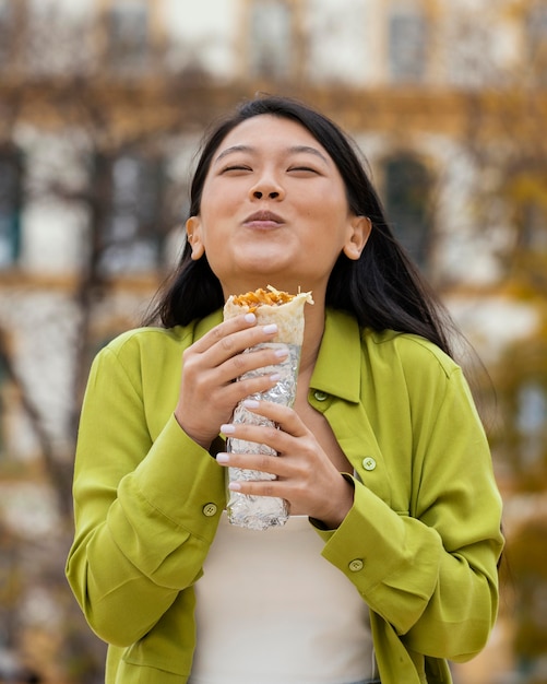 Photo femme mangeant de la nourriture de rue