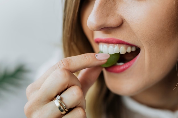 Femme mangeant un raisin vert