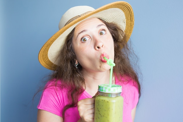 Femme mangeant sainement d'aliments biologiques buvant du jus de légumes frais de désintoxication verte crue mode de vie sain