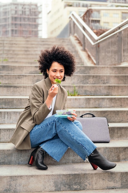 Femme mangeant une salade pendant une pause du travail