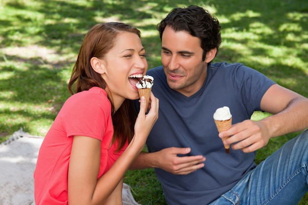 Femme, manger des glaces tout en restant assis avec son amie