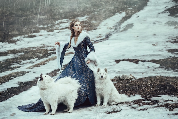 La femme en manteau bleu marche avec un chien