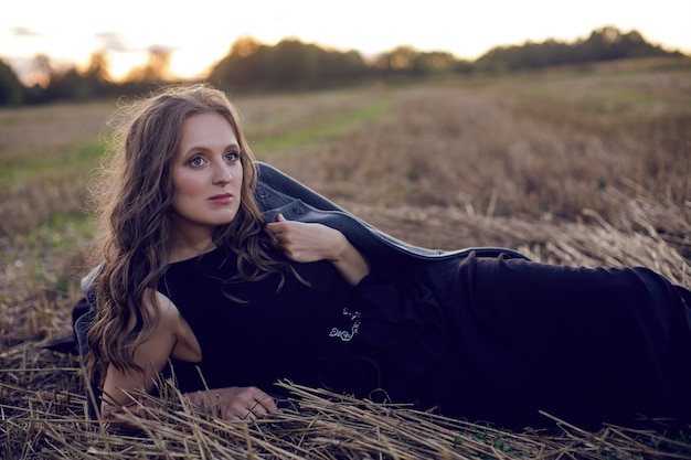 Femme En Manteau Gris Et Robe Noire Dans Le Champ Au Coucher Du Soleil à L'automne